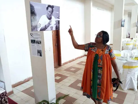 Devant un portrait de l'exposition « Femmes Pionnières ».