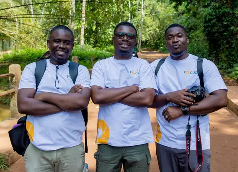Trois hommes en t-shirt « FOCUS » sur un chemin de forêt (à confirmer).