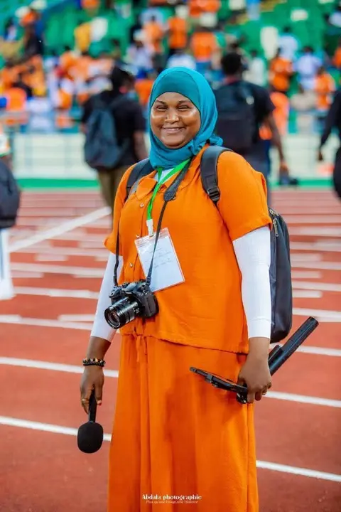 Photographe sur la piste d'un stade (personne à identifier).